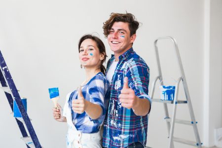 joven-mujer-enamorada-pintando-pared-mostrando-pulgares-arriba